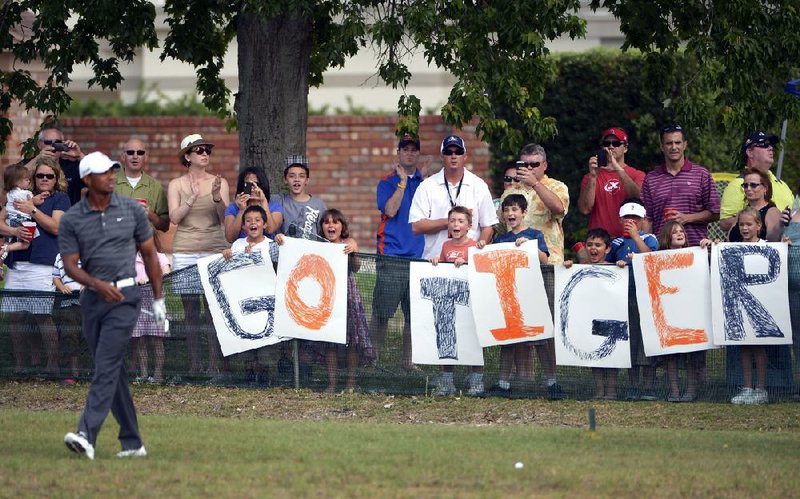 Fans cheer for Tiger Woods (left) after he hit a shot from the 15th fairway during Saturday’s third round of the Arnold Palmer Invitational in Orlando, Fla. Woods holds a one-stroke lead over Graeme McDowell going into today’s final round. 