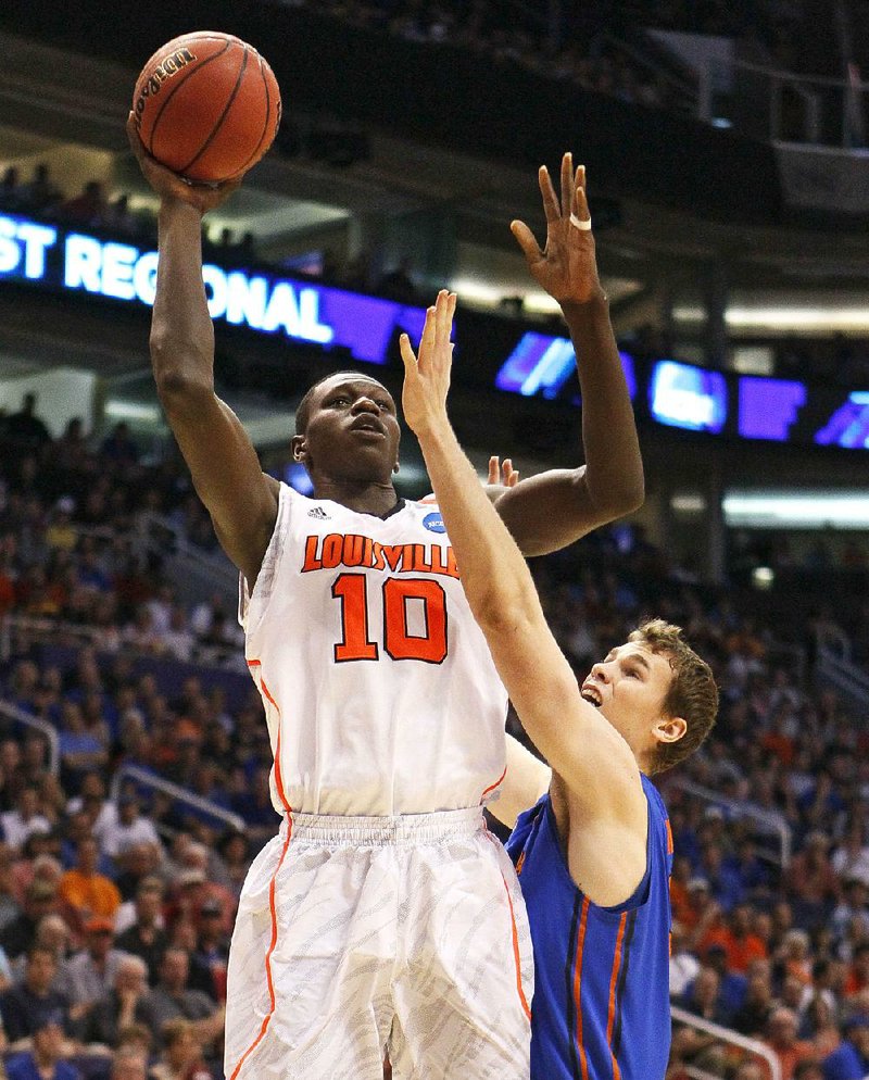 Louisville’s Gorgui Dieng (10) shoots over Florida’s Erik Murphy during the Cardinals’ 72-68 victory over the Gators on Saturday in the West Regional final in Phoenix. 