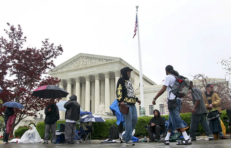 People wait in line Saturday in front of the Supreme Court building in Washington in hopes of getting a seat for Monday’s session on the health-care overhaul legislation. 