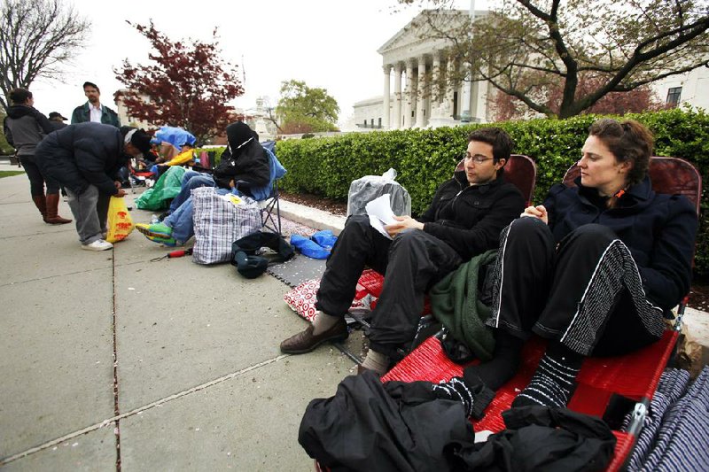 Jill Andres (right) and Brook Silva-Braga, both of New York City, camp out near the Supreme Court in Washington on Sunday as they wait in line for tickets to watch oral arguments in the health care-overhaul case.

