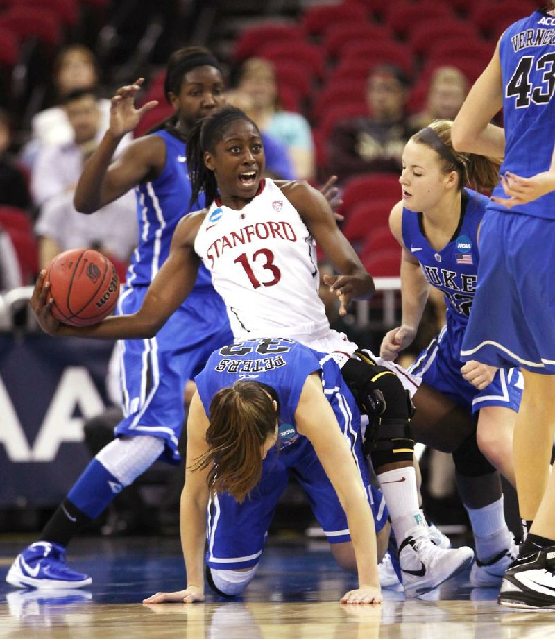 Stanford forward Chiney Ogwumike (center) falls over the top of Duke’s Haley Peters during the first half of Monday night’s game. Ogwumike scored 12 points and pulled down 17 rebounds while her sister, Nnemkadi, had a game-high 29 points to lead the Cardinal to an 81-69 victory over Duke in the Fresno Regional final. 