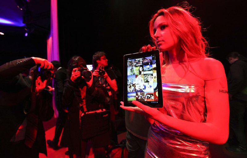 An employee displays Huawei Technologies Co.’s latest tablet device at an event before the Mobile World Congress exhibition last month in Barcelona. 