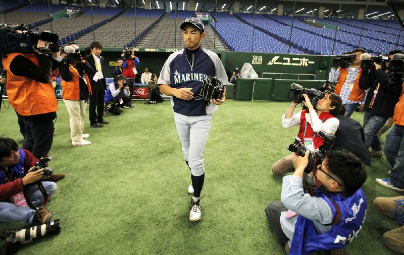 Japanese journalists focus their cameras on Seattle Mariners' Ichiro Suzuki before his team's practice at Tokyo Dome in Tokyo Tuesday, March 27, 2012. The Mariners will meet the Oakland Athletics in their two season-opening games of the Major League Baseball in Japan, at Tokyo Dome from Wednesday. (AP Photo/Itsuo Inouye)