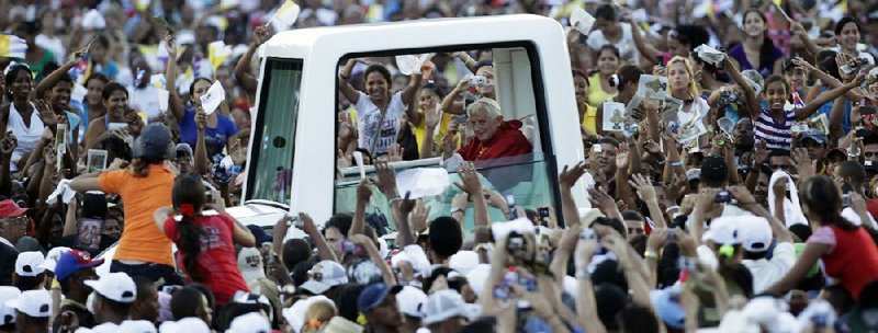 Pope Benedict XVI waves to faithful from his popemobile as he arrives at Revolution Square to celebrate a Mass in Santiago de Cuba, Cuba, Monday, March, 26, 2012. (AP Photo/Ramon Espinosa)