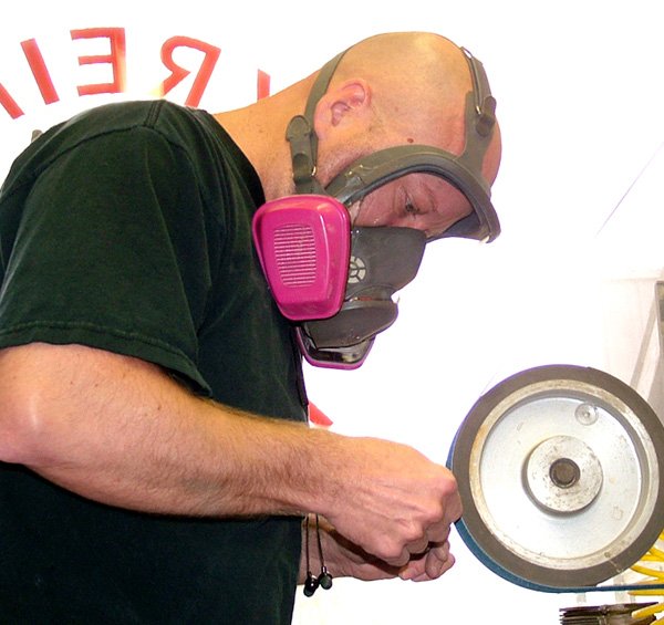 Tom Krein grinds a knife handle in his Gentry shop on Friday. Krein has continued to be busy, even during the slowdown in the economy.