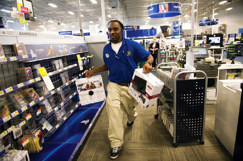 Derrial Davis stocks shelves Tuesday at a Best Buy in Emeryville, Calif. The company said it is working to minimize the effect of store closures on its workers. 