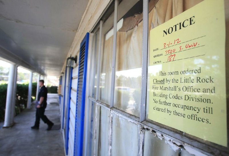 Assistant Fire Marshal Ryan Baker walks out of a room at the Heritage House Inn during a code inspection March 1. A Pulaski County circuit judge Thursday ordered the motel to be closed until its owner corrects building and fire-code violations. The move displaced about four dozen people living there.