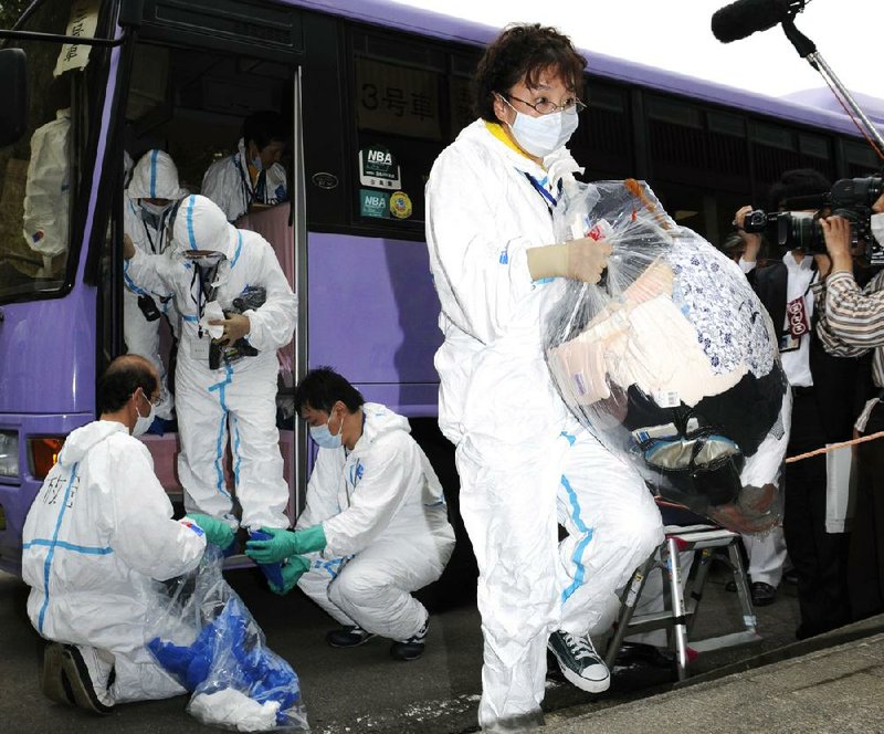 Villagers get off a bus last May after being allowed to visit their homes near the Fukushima Daiichi nuclear plant for the first time since the March 11, 2011, earthquake and tsunami. 