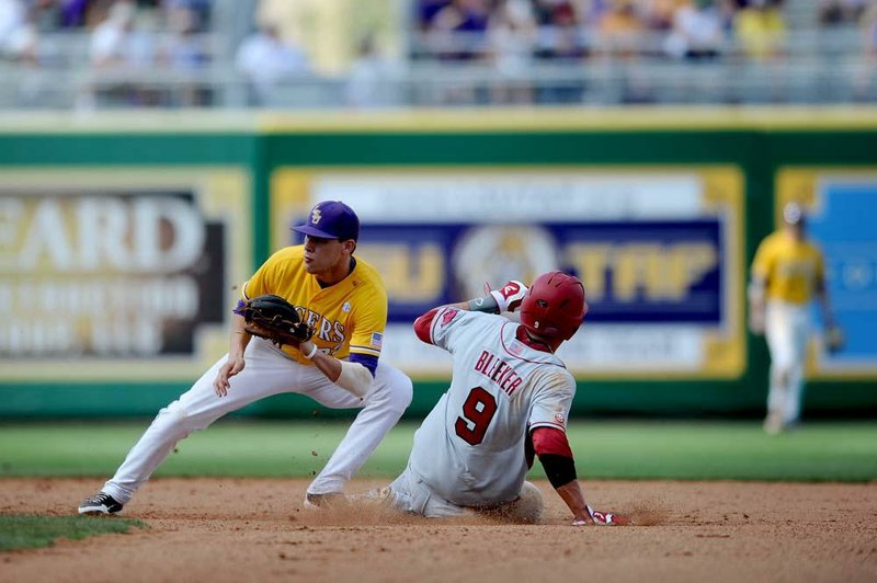 Arkansas’ Derek Bleeker slides in safely to second base in front of LSU’s JaCoby Jones during the Razorbacks’ 3-2 11-inning loss Sunday at Alex Box Stadium in Baton Rouge. 