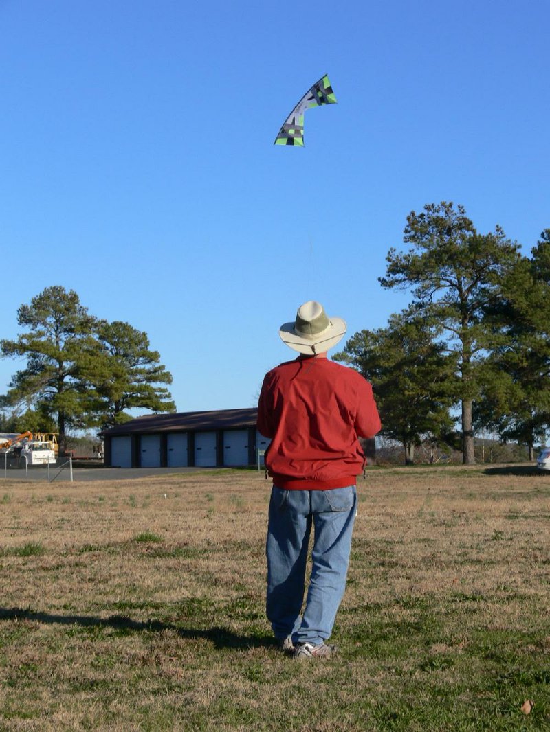 Robert Lassonde finds the open fields beside the Andrew Hulsey Fish Hatchery in Hot Springs a good place to catch the wind as he practices with his quad-line sport kite in March. 