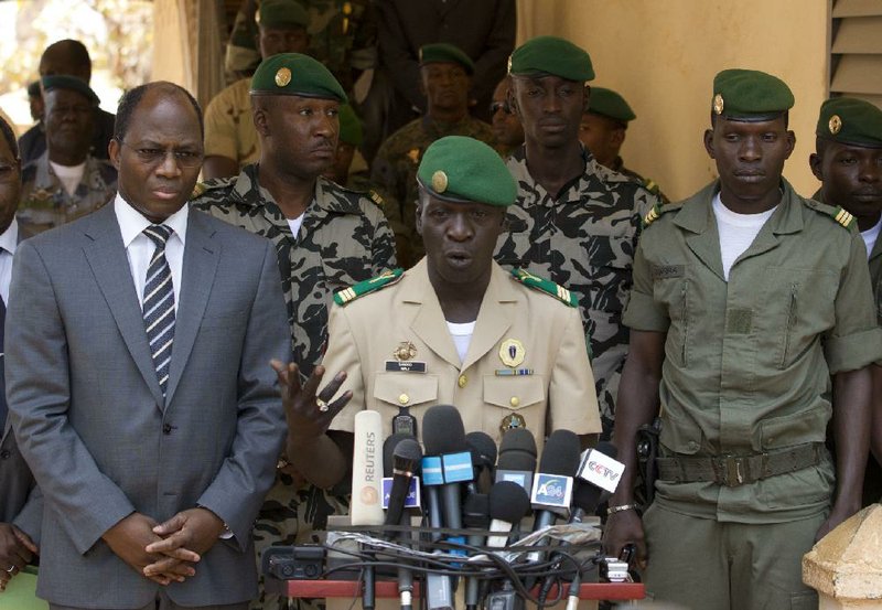 Coup leader Capt. Amadou Haya Sanogo (center) speaks to the media Sunday at junta headquarters in Kati, Mali. 