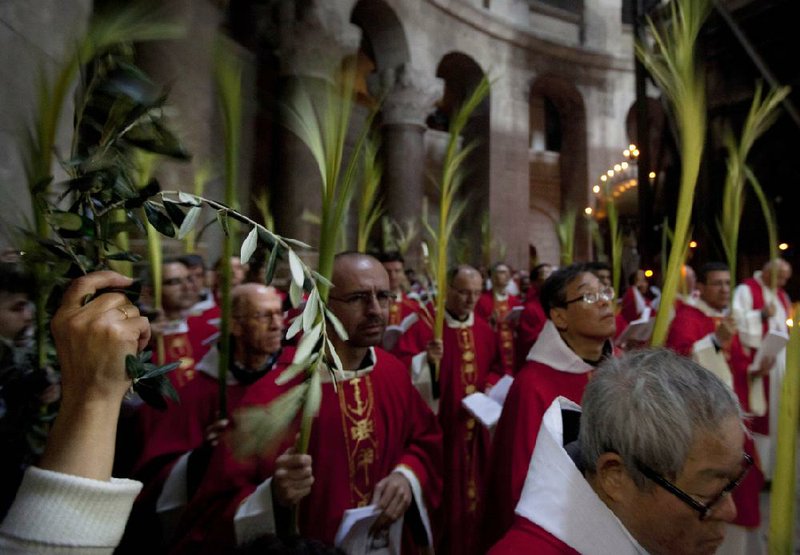 Catholic priests carry palm fronds at the Church of the Holy Sepulcher in Jerusalem’s Old City on Sunday. 