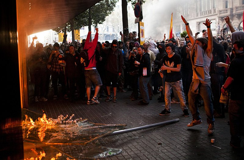 Demonstrators burn a shop in Barcelona during a protest over labor overhauls late last week. Spain’s cost of borrowing rose again Thursday over concerns about its ability to handle its debts. 