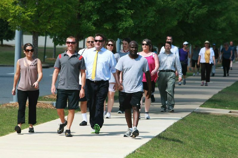 Participants in the Little Rock River Market section of Downtown Partnership’s new Monday Mile walking program stride April 2 through the Clinton Presidential Park in Little Rock. 