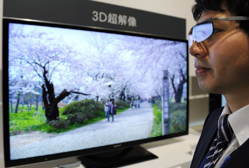 A Sony Corp. employee demonstrates 3-D glasses used with the company’s Bravia LCD television on display in Tokyo in March. 