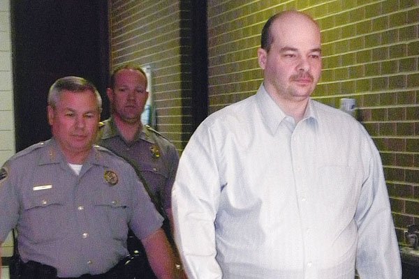 Officers escort Rene Bourassa into court Friday at the Cross County Courthouse in Wynne, where he was sentenced to life in prison without parole in the slaying of Lillian WIlson. 