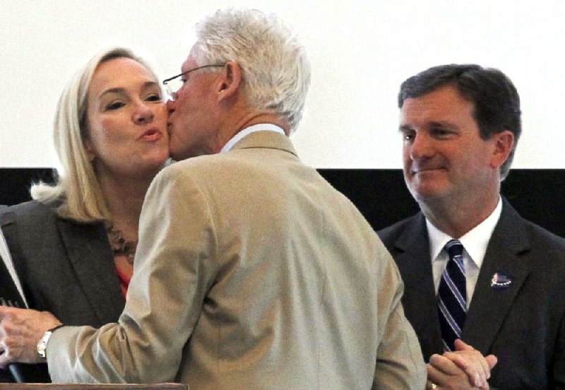 Former President Bill Clinton greets Stephanie Streett, Clinton Foundation executive director, and John Brown, Windgate Foundation executive director, before speaking at the kickoff of the Arkansas Arts Summit, a conference designed to help build strong arts organizations. Clinton later traveled to El Dorado, encouraging students to further their education with help from El Dorado Promise scholarships. 