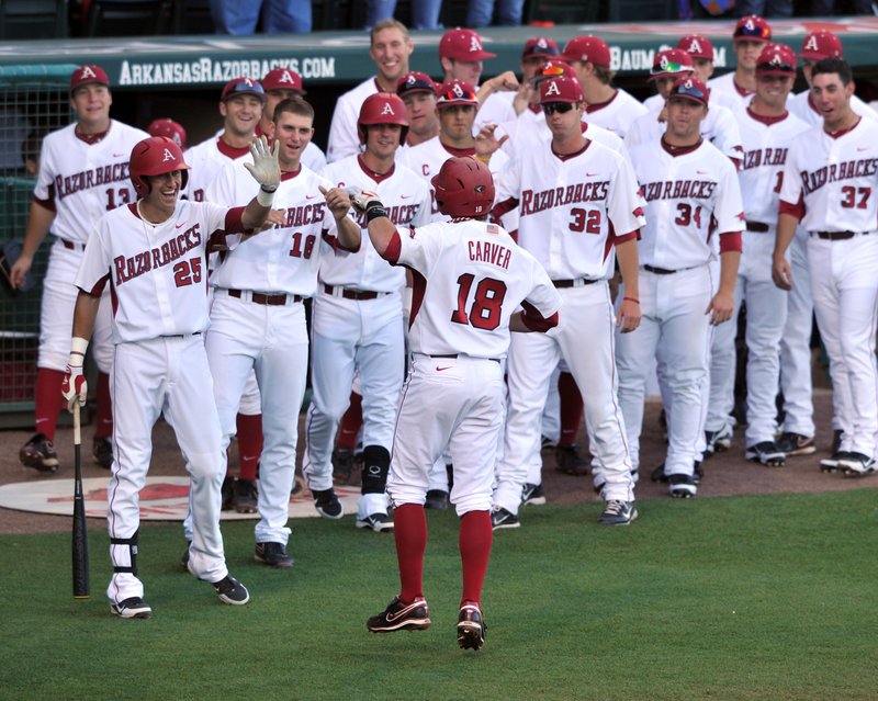 Arkansas Democrat-Gazette/MICHAEL WOODS --04/24/2012-- Arkansas shortstop Tim Carver is greeted by teammates after hitting a solo home run in the first inning of Tuesday night's game against Oral Roberts at Baum Stadium in Fayetteville.