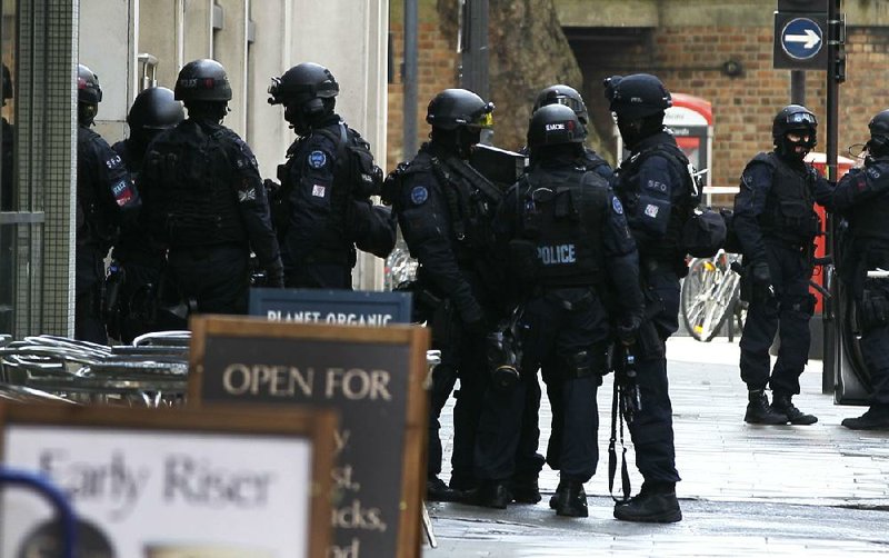 Armed police enter a building near Tottenham Court Road in London on Friday after a woman reported that a man had walked into her office and threatened to blow himself up. 