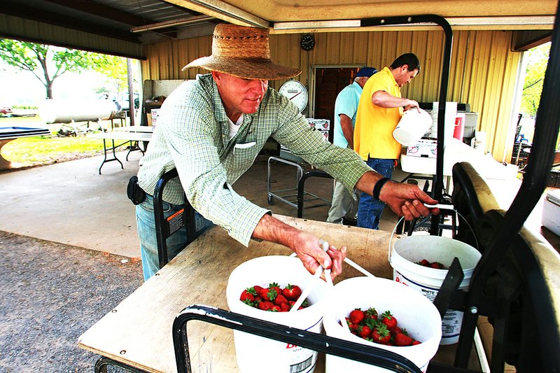 Rex Barnhill unloads buckets of strawberries that had just been picked at Barnhill Farm in Lonoke County on Thursday. 