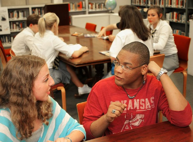 Lauren Zell (left) and Chris Taylor chat recently in the media center at St. Joseph Catholic High School in Pine Bluff. The school is struggling to stay open. 
