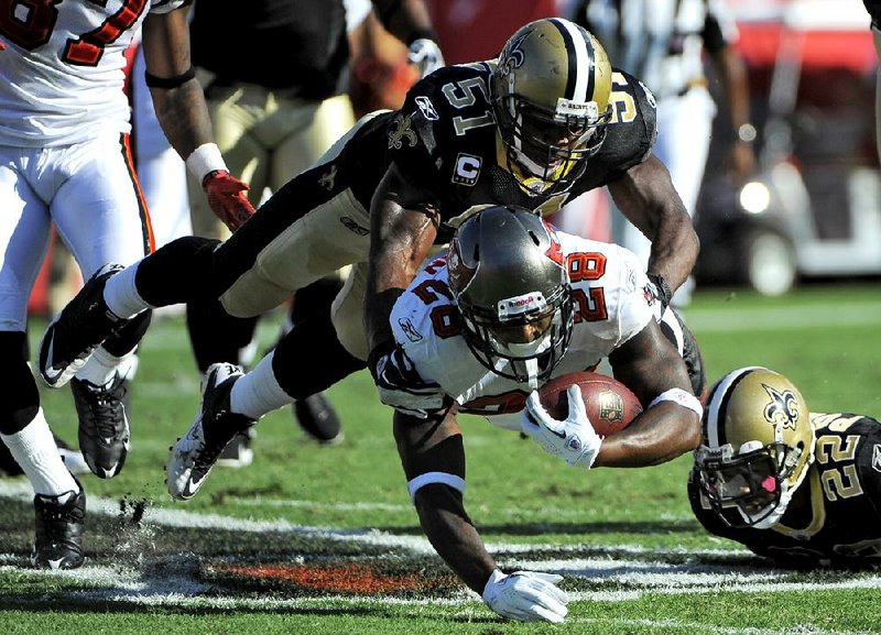FILE - This Oct. 16, 2011 file photo shows New Orleans Saints linebacker Jonathan Vilma (51) taking down Tampa Bay Buccaneers running back Kregg Lumpkin (28) during the second quarter of an NFL football game, in Tampa, Fla. Vilma has been suspended without pay for the entire 2012 season by the NFL, one of four players punished for participating in a pay-for-pain bounty system. NFL Commissioner Roger Goodell's ruling was announced Wednesday, May 2, 2012 . (AP Photo/Brian Blanco, File)