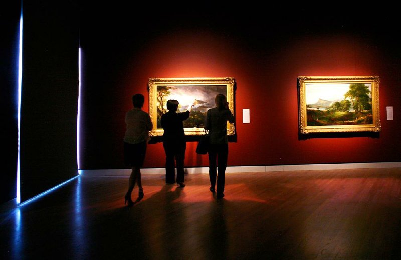 Arkansas Democrat-Gazette/JASON IVESTER --05/03/12--
Museum employees look over some of the paintings in the newly installed Hudson River School exhibit inside Crystal Bridges Museum of American Art in Bentonville on Thursday, May 3, 2012. The travelling exhibit opens to members today (FRIDAY) and to the public on Saturday. Reserved time tickets are required for the exhibit, which will stay through Sept. 3, and cost $5 for non-members or free for members.