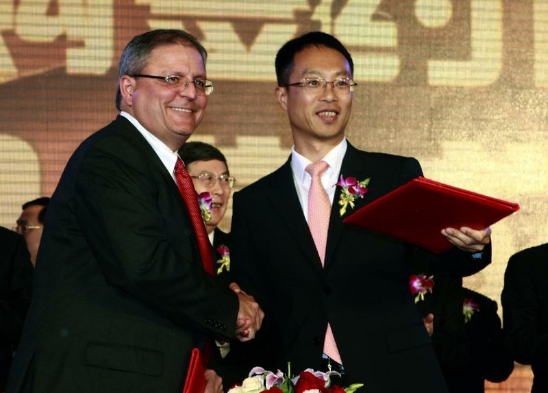 Gerry Lopez (left), chief executive officer of AMC Entertainment Holdings, joins Zhang Lin, vice president of Dalian Wanda Group Co., during a ceremony Monday in Beijing. 