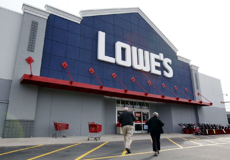 Customers head to a Lowe’s store in Saugus, Mass., in this November photo. The home-improvement company attributed a climb in first-quarter sales to unseasonably warm weather this spring. 