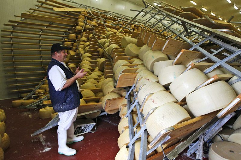 Oriano Caretti looks at the overturned shelves of Parmesan wheels in his Parmesan cheese factory in San Giovanni in Persiceto, Italy, on Monday. 