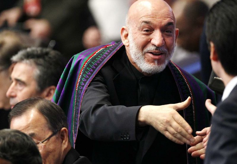 Afghan President Hamid Karzai greets people as he arrives at the meeting Monday on Afghanistan during the NATO summit in Chicago. 