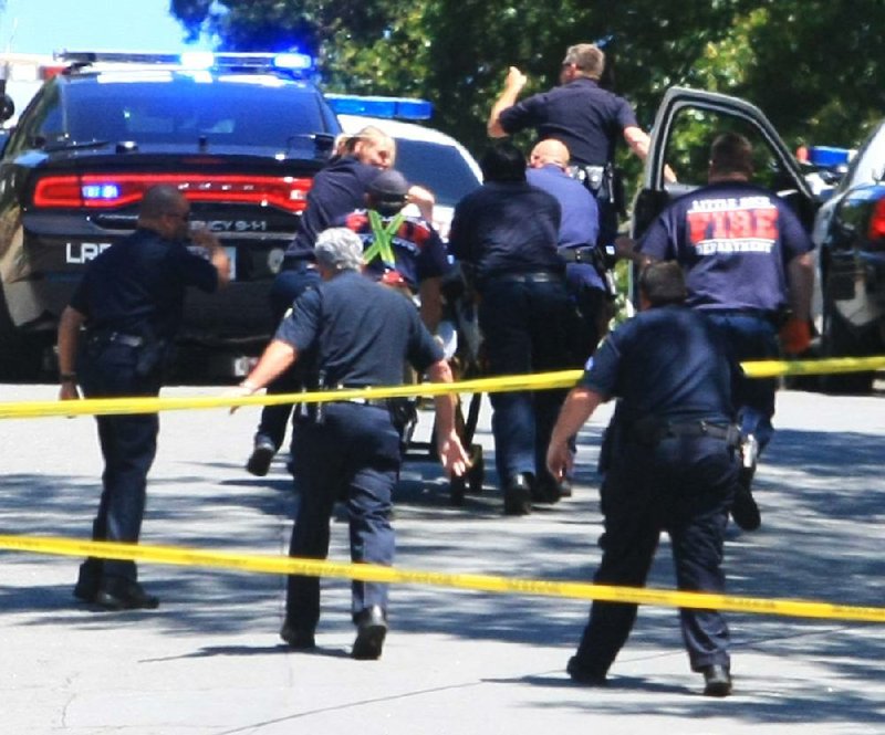 Arkansas Democrat-Gazette/RICK MCFARLAND --05/22/12-- Emergency personnel rush a man shot by a Little Rock Police officer to an ambulance in the 300 block of Thayer St. in Little Rock Tuesday. He later died. The man had a gun and ran from a home at 204 Thayer St. that officers had responded to on a suspected burgulary call. Two men, one fatally, had been shot inside the home. It had not yet been determined by who. 