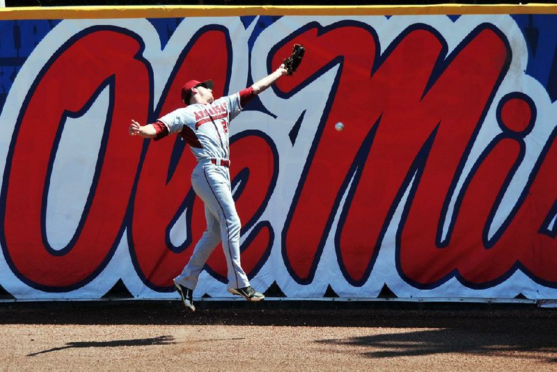 University of Arkansas center fielder Matt Vinson leaps against the wall as he tries to make the play in the 4th inning of their game against Ole Miss during the second day of the SEC baseball tournament at Regions Park in Hoover, Alabama.