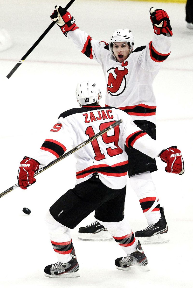 New Jersey Devils' Zach Parise, top, celebrates after scoring on an open net with Travis Zajac during the third period of Game 5 of an NHL hockey Stanley Cup Eastern Conference final playoff series against the New York Rangers, Wednesday, May 23, 2012, in New York. The Devils won 5-3. (AP Photo/Julio Cortez)