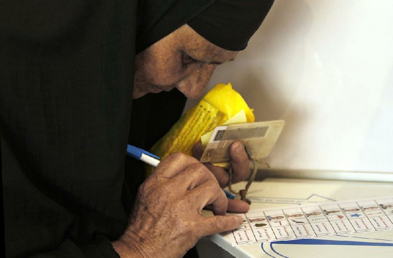 An Egyptian woman marks her ballot Wednesday at a polling station in Alexandria during the first day of voting in the presidential election.

