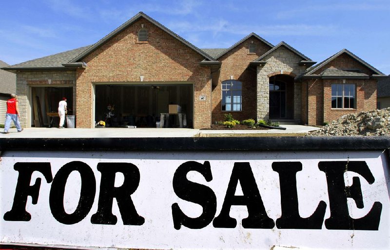 Construction workers put the finishing touches on a new home for sale in Springfield, Ill. in this May 23 file photo.