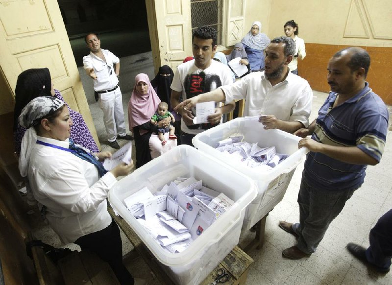 An Egyptian judge (left) and election officials count votes Thursday at a polling station in Cairo. 
