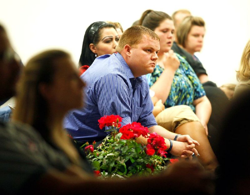 Members of Teena Evans’ family view a video during a ceremony Friday marking the first anniversary of a tornado that killed Evans and two others in Franklin County. 
