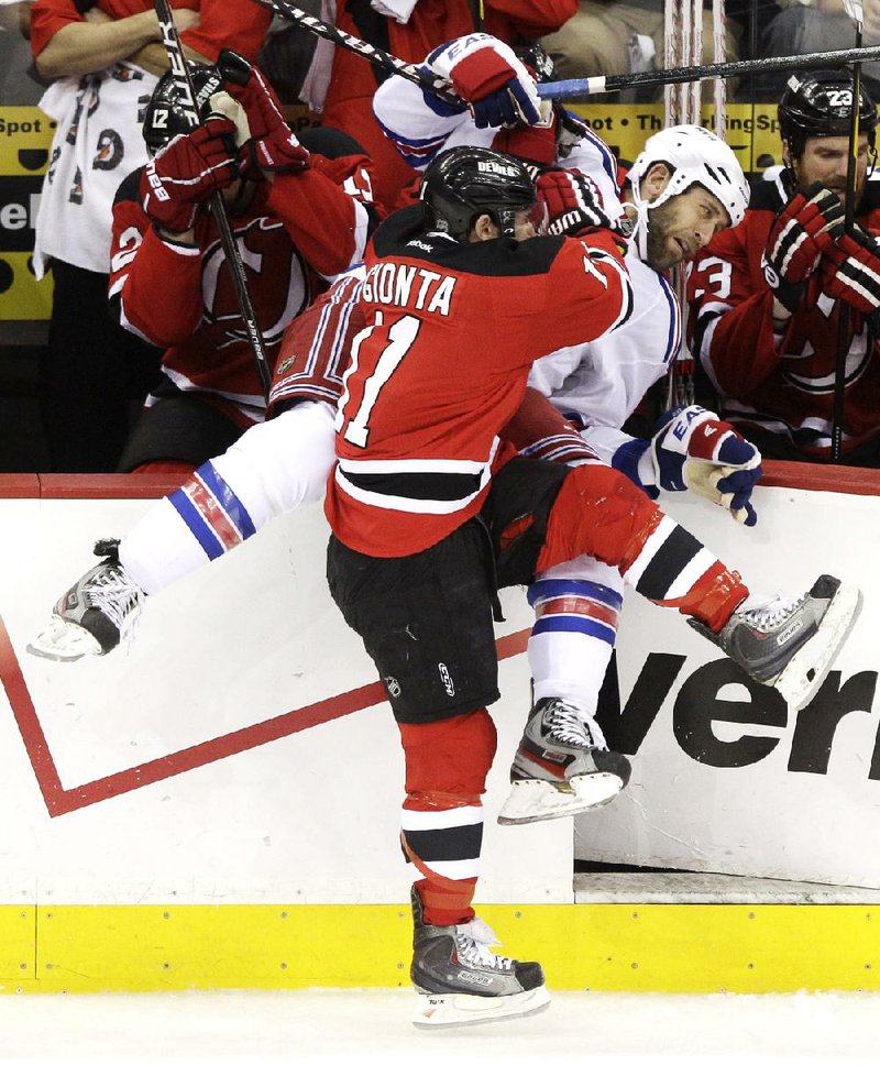 New York Rangers center Mike Rupp (right) is checked into the boards by New Jersey Devils right winger Stephen Gionta on Friday during Game 6 of the NHL Eastern Conference final. 