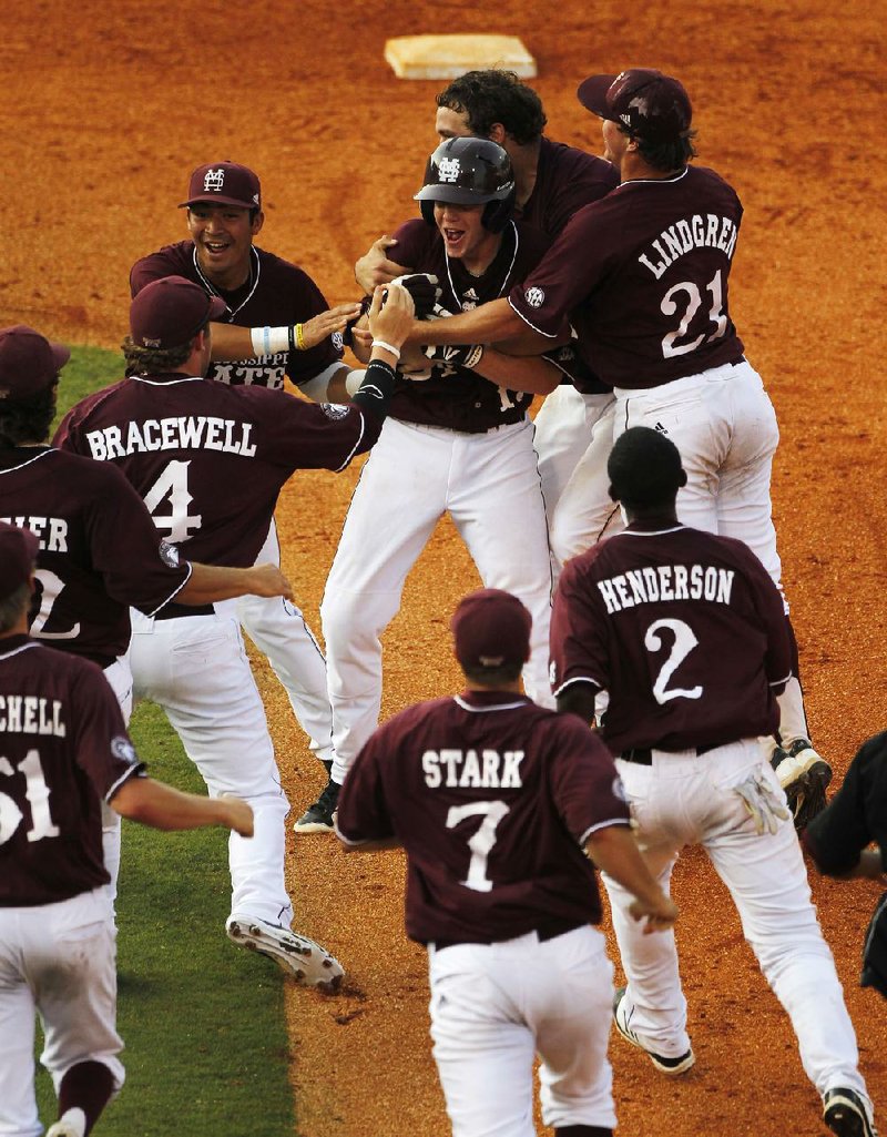Mississippi State’s Matthew Britton (center) is swarmed by teammates after he drove in the game-winning run on a single up the middle as the Bulldogs eliminated LSU with a 4-3 victory Friday at the SEC tournament in Hoover, Ala. 