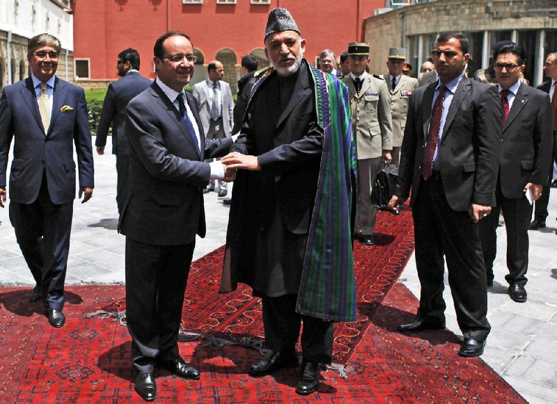 Afghan President Hamid Karzai greets French President Francois Hollande upon Hollande’s arrival Friday in Kabul. 