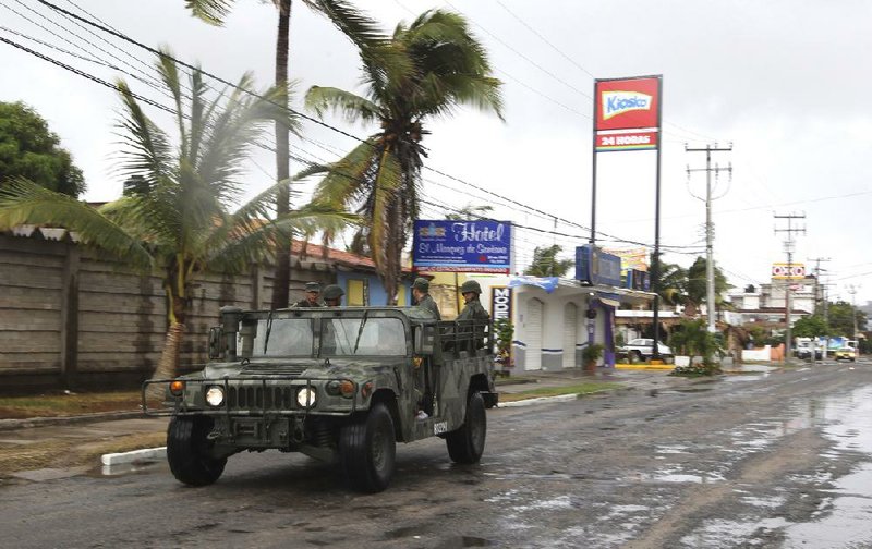 A navy vehicle moves along a street Friday in the coastal town of Barra de Navidad as Hurricane Bud bears down on Mexico’s Pacific coast. 