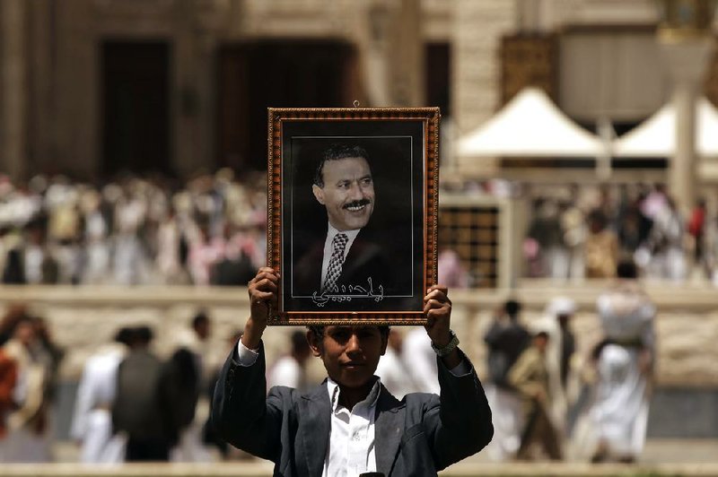 A supporter of Yemen’s former President Ali Abdullah Saleh holds up Saleh’s portrait during a rally Friday in Sana to demand the trial of those involved in the attempted assassination of Saleh. 