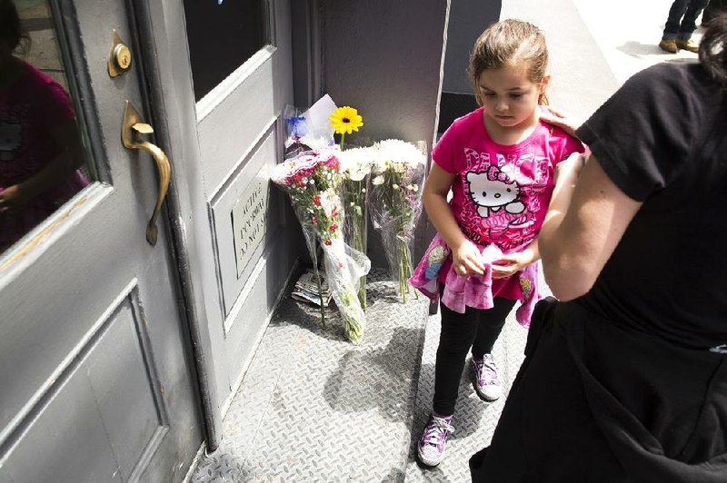 Supporters of the Patz family leave flowers on the family’s doorstep Friday in New York.