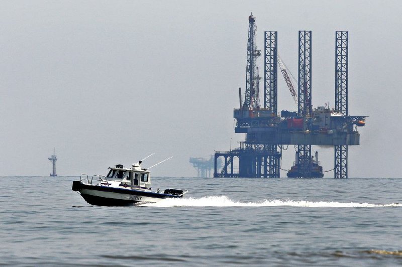 A patrol boat passes near an oil platform off the coast of Louisiana in the Gulf of Mexico in May 2010. 