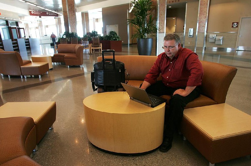 Arkansas Democrat-Gazette/RYAN MCGEENEY --04-26-2012-- Zane Phifer of Greensboro, N.C., works on a laptop computer between flights Thursday morning at XNA. The airport has recently updated its concourse, to include more comfortable furniture, higher-end restaurants and bars, and Arkansas' first moving walkway.

