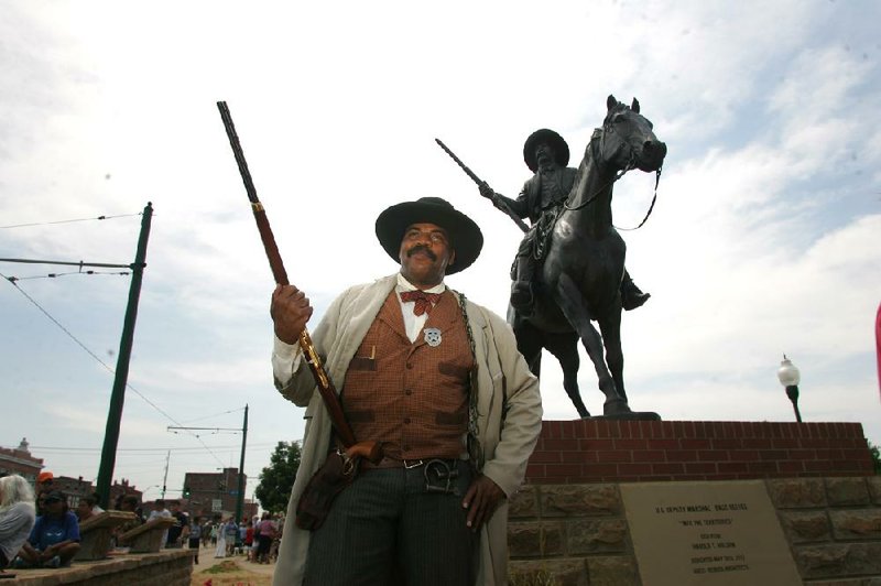 Baridi Nkokheli of Fort Smith portrays Deputy U.S. Marshal Bass Reeves in front of a statue of Reeves that was unveiled Saturday in Ross Pendergraft Park in Fort Smith. 