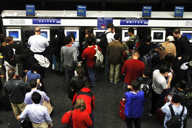 Passengers crowd the kiosks to check in and print boarding passes at San Francisco International Airport in San Francisco in this file photo. 