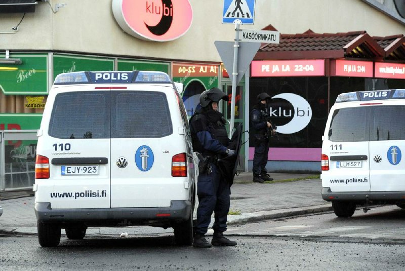 Police officers guard the area where a gunman opened fire Saturday in Hyvinkaa, Finland. 