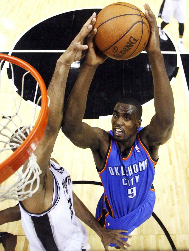 Oklahoma City’s Serge Ibaka goes toward the basket but runs into San Antonio’s Tim Duncan who tries for the block in the first half of their NBA Western Conference final in San Antonio on Tuesday. The Spurs won 120-111, giving them a 2-0 lead in the best-of-7 series. 